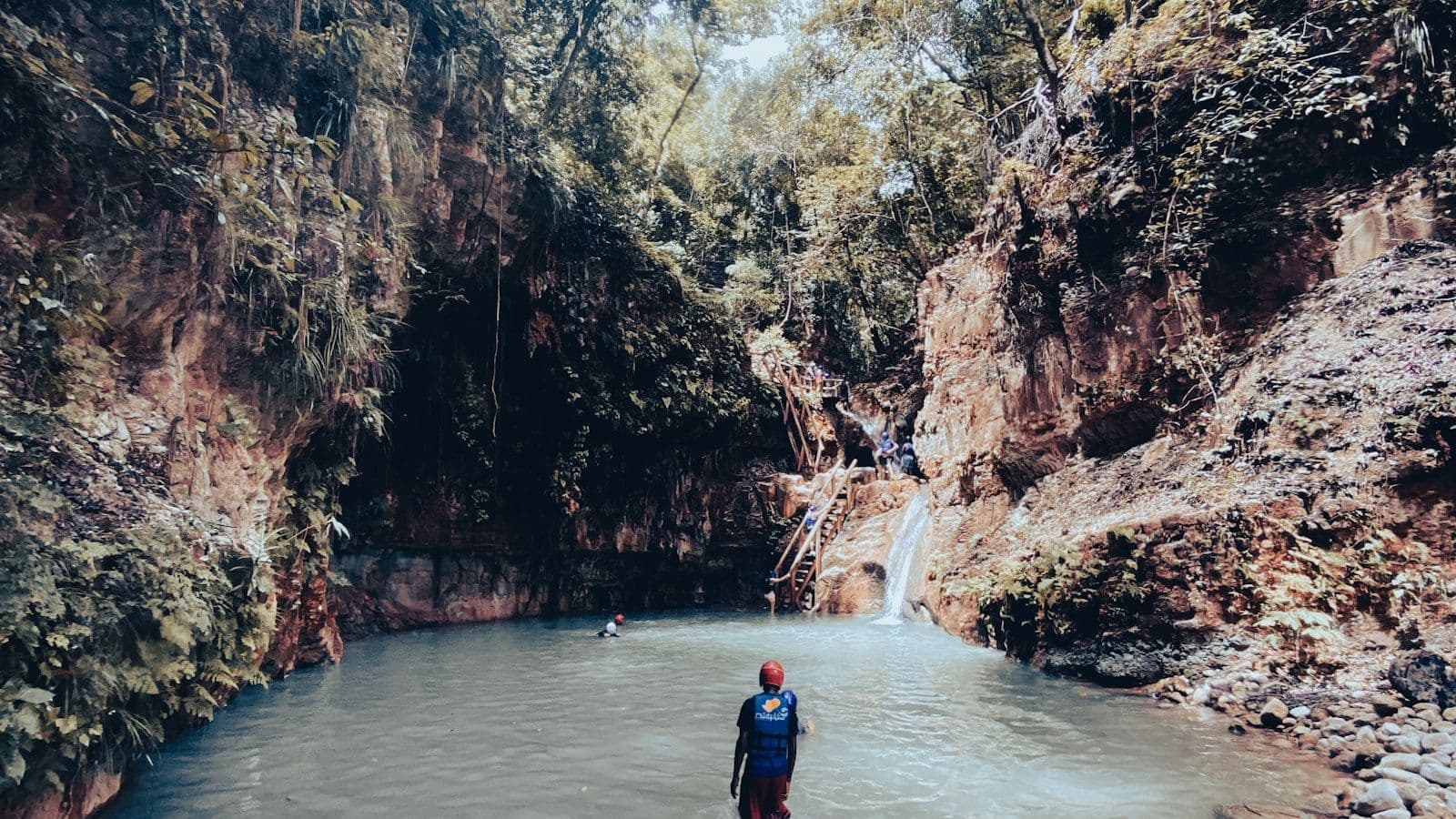 Persona explorando un río entre rocas en Puerto Plata